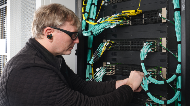 A person working on a data center rack.