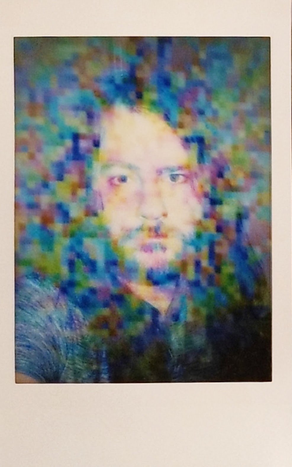 double-exposure Instax instant photo of tgies shows a face surfacing through a wash of RGB scan-pixels